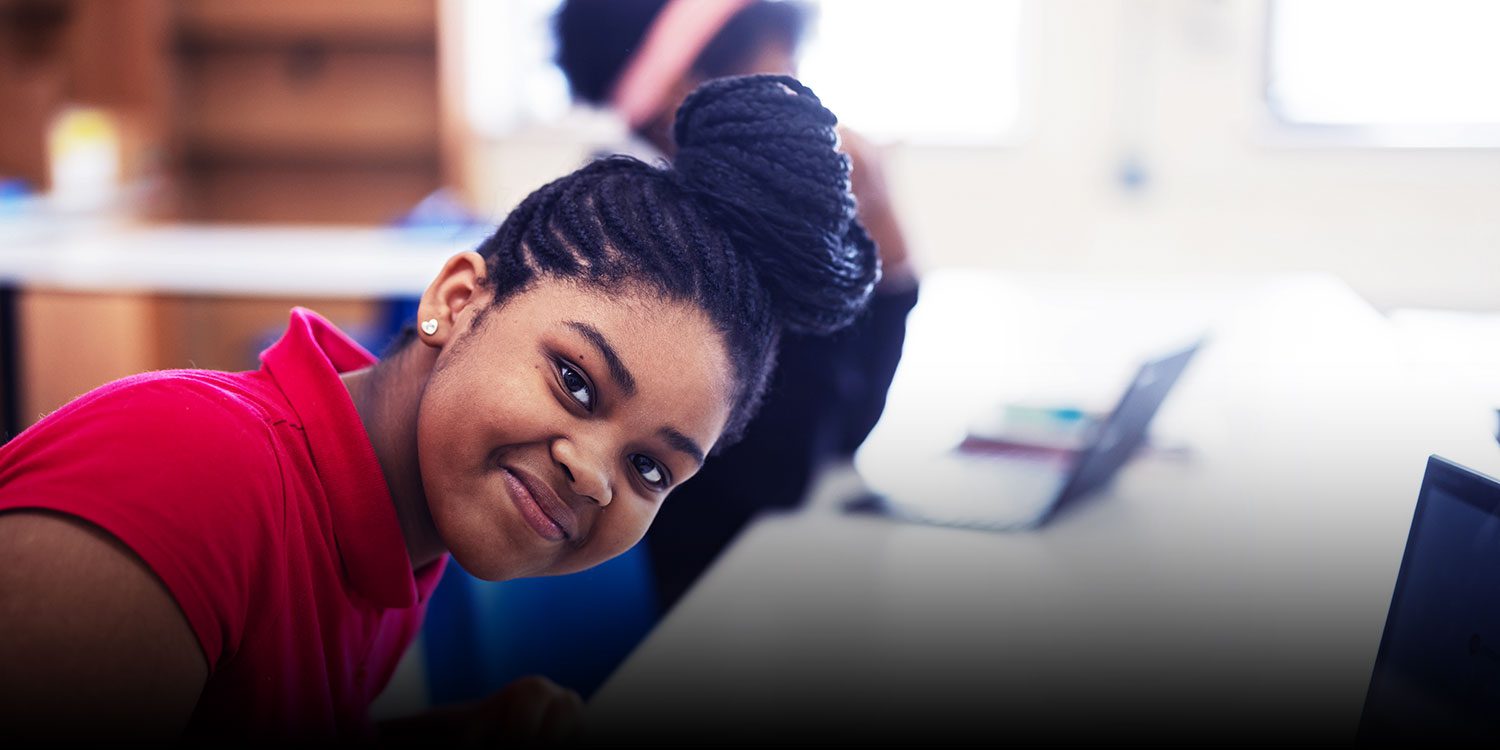 Smiling student in a classroom.