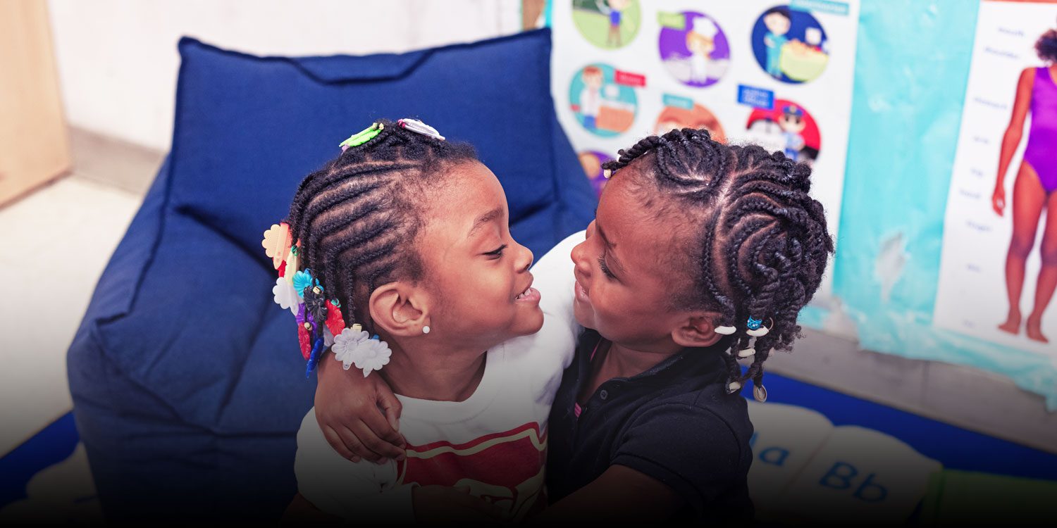 Smiling students hugging each other