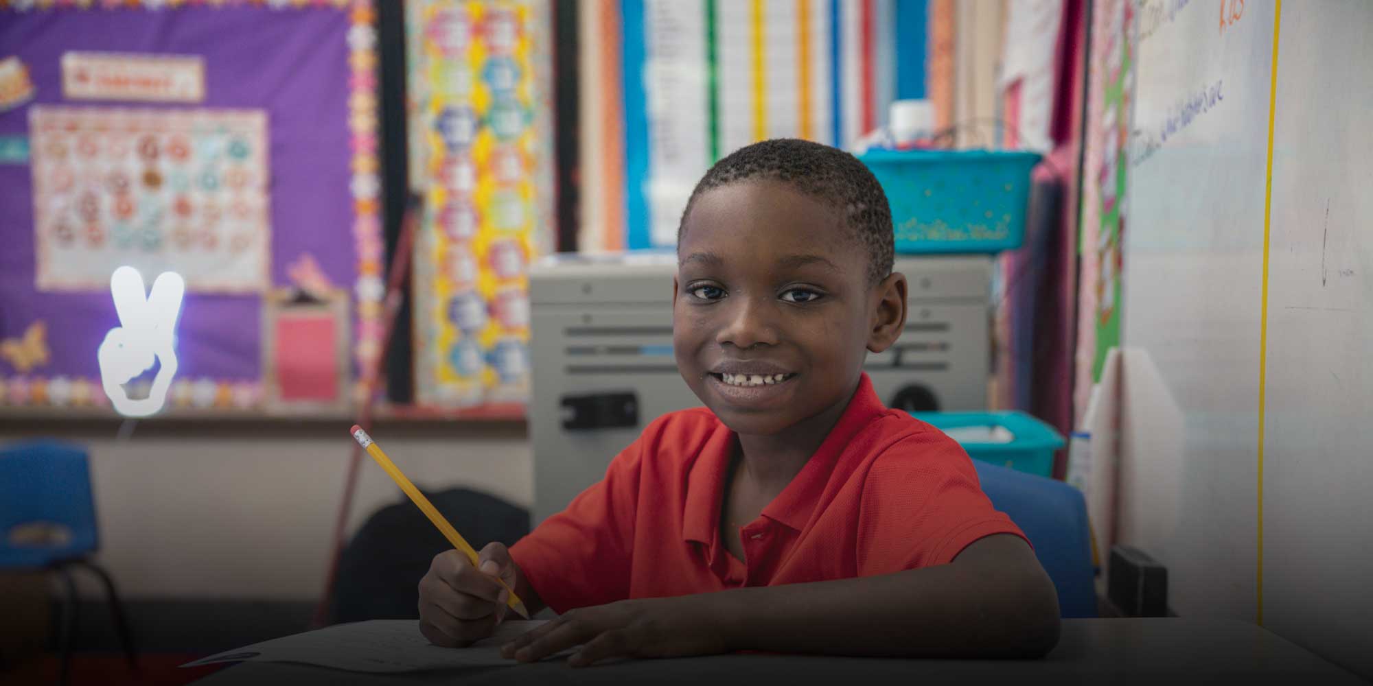 Smiling student writing in class